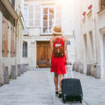 hotel, tourist walking with suitcase on the street